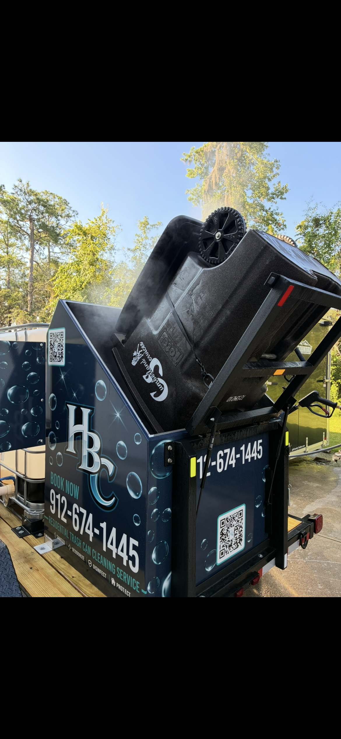 Harbor Bin Care branded trailer cleaning a bin